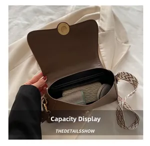 Interior capacity of brown pebbled leather crossbody bag with items and geometric strap