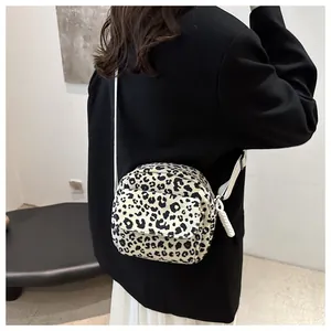 Detail of leopard print crossbody bag with white adjustable strap and front pocket
