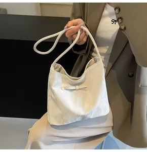 Vue détaillée du sac porté épaule jacquard blanc avec nœud, porté par un mannequin