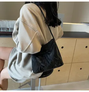Vue détaillée d'un sac cabas noir plissé avec nœud porté à l'épaule par un mannequin