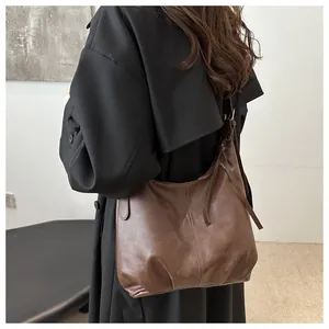 Detail einer großen braunen Hobo-Tasche aus mattem Vintage-Leder mit seitlichen Kordelzügen