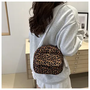 Detail of leopard print crossbody bag with white rope strap and front pocket storage