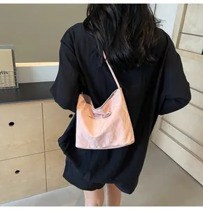 Détail du cabas rose clair avec texture satinée plissée et nœud porté à l'épaule