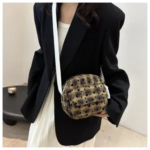 Close-up of heart patterned plaid saddle bag with white strap on model in black suit