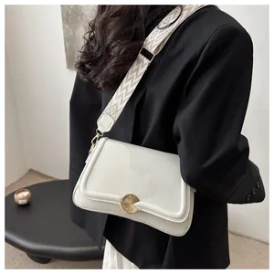 Detail of off-white grain leather crossbody bag with wide geometric woven strap
