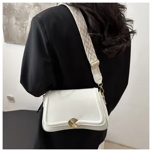 Detailed shot of white lychee leather bag with wide geometric woven shoulder strap