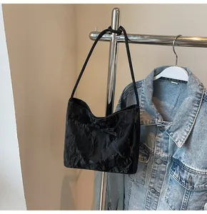 Détail du sac cabas noir texturé avec un nœud décoratif et de fines bandoulières