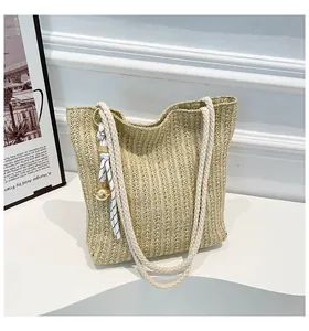 Detailed close-up of woven straw tote bag texture with elegant ribbon and bell charm