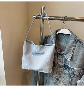 Détail du sac cabas bleu clair avec texture plissée unique et petit nœud décoratif chic