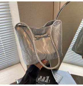 Gros plan sur un sac cabas argenté avec texture plissée et détail de petit nœud
