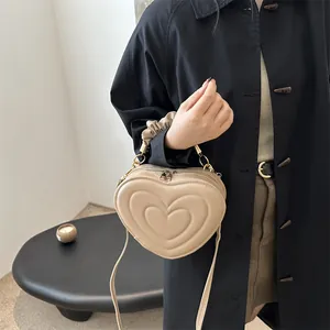 Vintage heart-shaped shoulder bag in beige faux leather with ruched handle and gold zippers