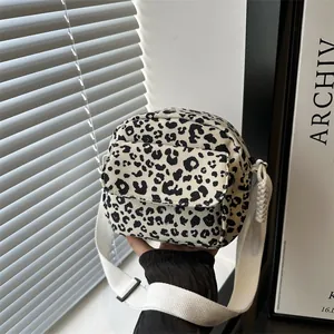 Modern black and white leopard print crossbody bag with a wide woven shoulder strap