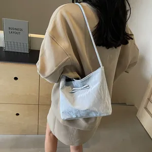 Sac fourre-tout bleu clair métallisé avec nœud porté à l'épaule par un mannequin