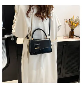 Model wearing a black glossy PU leather crossbody bag with a beige trench coat