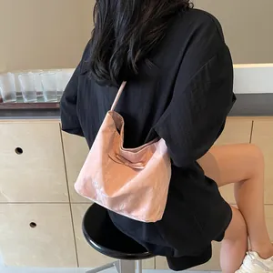 Sac fourre-tout plissé rose pâle avec nœud, porté comme un sac à bandoulière élégant