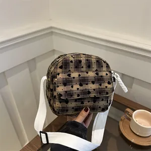 Brown plaid saddle bag with black hearts and white woven strap for casual wear