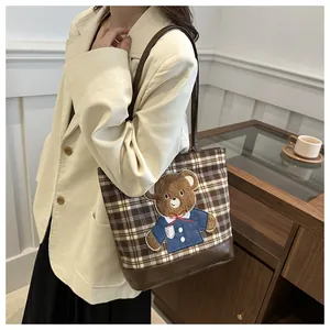 Detail of vintage plaid tote bag featuring a cute 3D bear embroidery and leather base