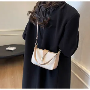 Detail of a chic contrast color crossbody bag styled with a minimalist black outfit