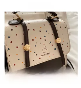Close-up of the vintage rabbit print and metallic buckle on the white textured bag