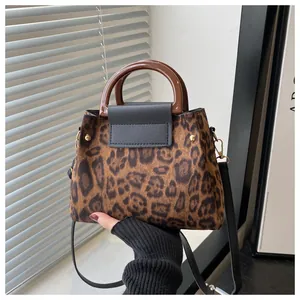 Detail of leopard print tote bag with resin handle and fine faux fur texture close-up