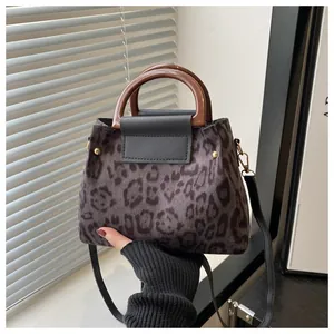 Macro detail of leopard print faux suede fabric with elegant dark wood round handles