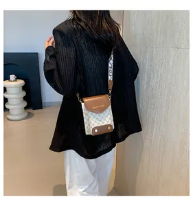 Dettaglio borsa a tracolla bianca monogram con finiture in pelle marrone e tracolla larga