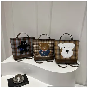 Detailed view of three plaid canvas tote bags with bear, cat, and dog cartoon patches