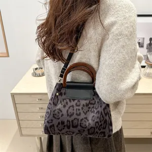 Retro leopard print crossbody bag with wooden handle and black leather shoulder strap