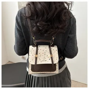 Detail of contrast stitch backpack featuring colorful polka dots and Aimity 1986 logo