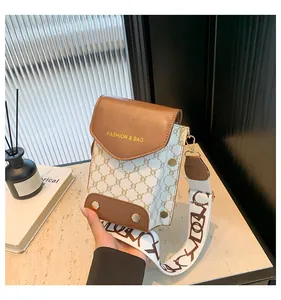 Dettaglio della borsa porta cellulare monogramma con patta in pelle e tracolla larga