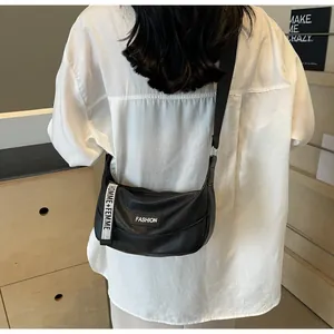 Borsa a mezzaluna nera a grana di litchi indossata a tracolla con tracolla tessuta