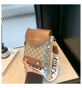 Dettaglio della borsa porta cellulare vintage con logo dorato e tracolla in tela