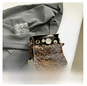 Detail showing internal capacity of leopard print handbag with metal U-lock and phone