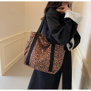 Detail of leopard print tote bag showing the side pocket and wide black straps