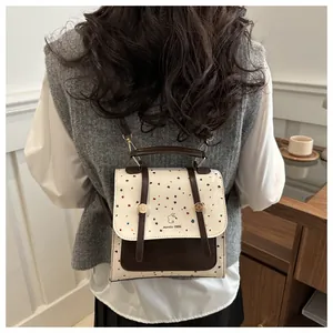 Detail shot of a small beige and brown faux leather backpack with adjustable straps