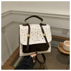 Detailed close-up of retro cream leather backpack with Aimity 1986 logo and polka dots