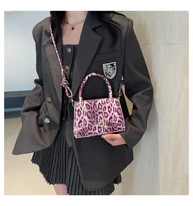 Close-up of pink leopard print faux fur handbag with gold metal hardware and strap