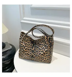Detailed close-up of stylish leopard print tote bag with textured leather and long straps