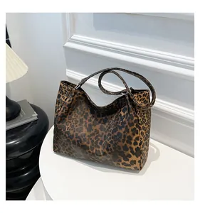 Detailed view of leopard print tote bag with adjustable strap in a stylish interior setting