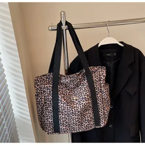 Macro shot of large leopard print tote bag with black strap and side pocket detail