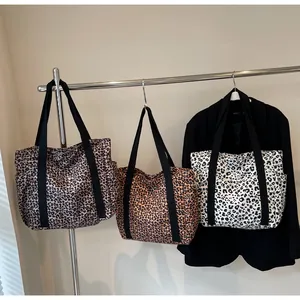 Three leopard print tote bags in brown, orange and grey hanging with side pockets