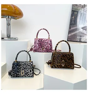 Detail of leopard print faux fur handbags with gold oval locks in pink, brown, and grey