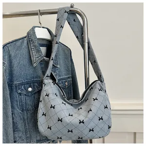 Nahaufnahme der blauen Cord-Tasche mit schwarzer Schleifenstickerei und Steppmuster