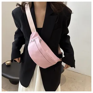 Detail of pink minimalist crossbody chest bag with adjustable strap and silver zipper