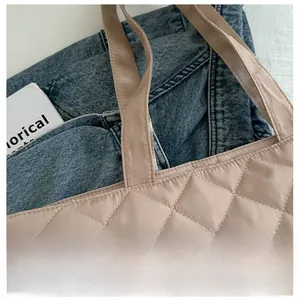 Détail des coutures matelassées en losange sur la surface du sac cabas en nylon beige