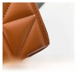 Close-up of brown leather bag showing fine diamond quilting and precise stitching detail