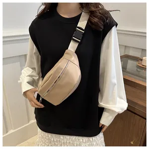 Detalle del bolso de pecho beige minimalista con correa tejida ancha y cierre de hebilla