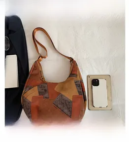 Dettaglio della borsa tote patchwork vintage con trame in pelle terra e tracolla larga