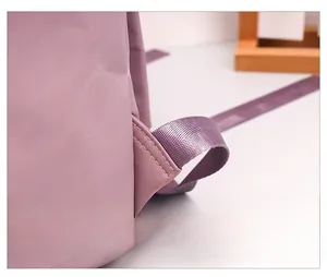 Détail de la couture triangulaire renforcée sur la bretelle du sac à dos en nylon violet