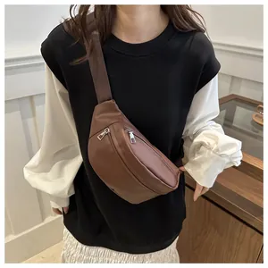 Detalle del bolso de pecho en cuero PU marrón oscuro con cremalleras plateadas